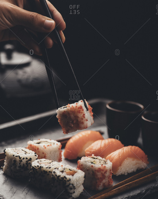 Eating sushi rolls with salmon and tuna fish.