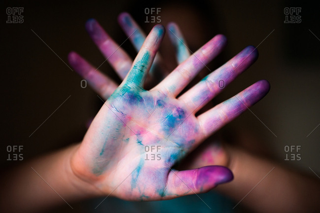 Close-up of a childs hands covered in bright colored dye