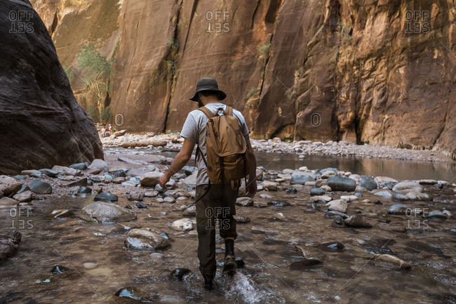 Man hiking through the narrows Zion National Park