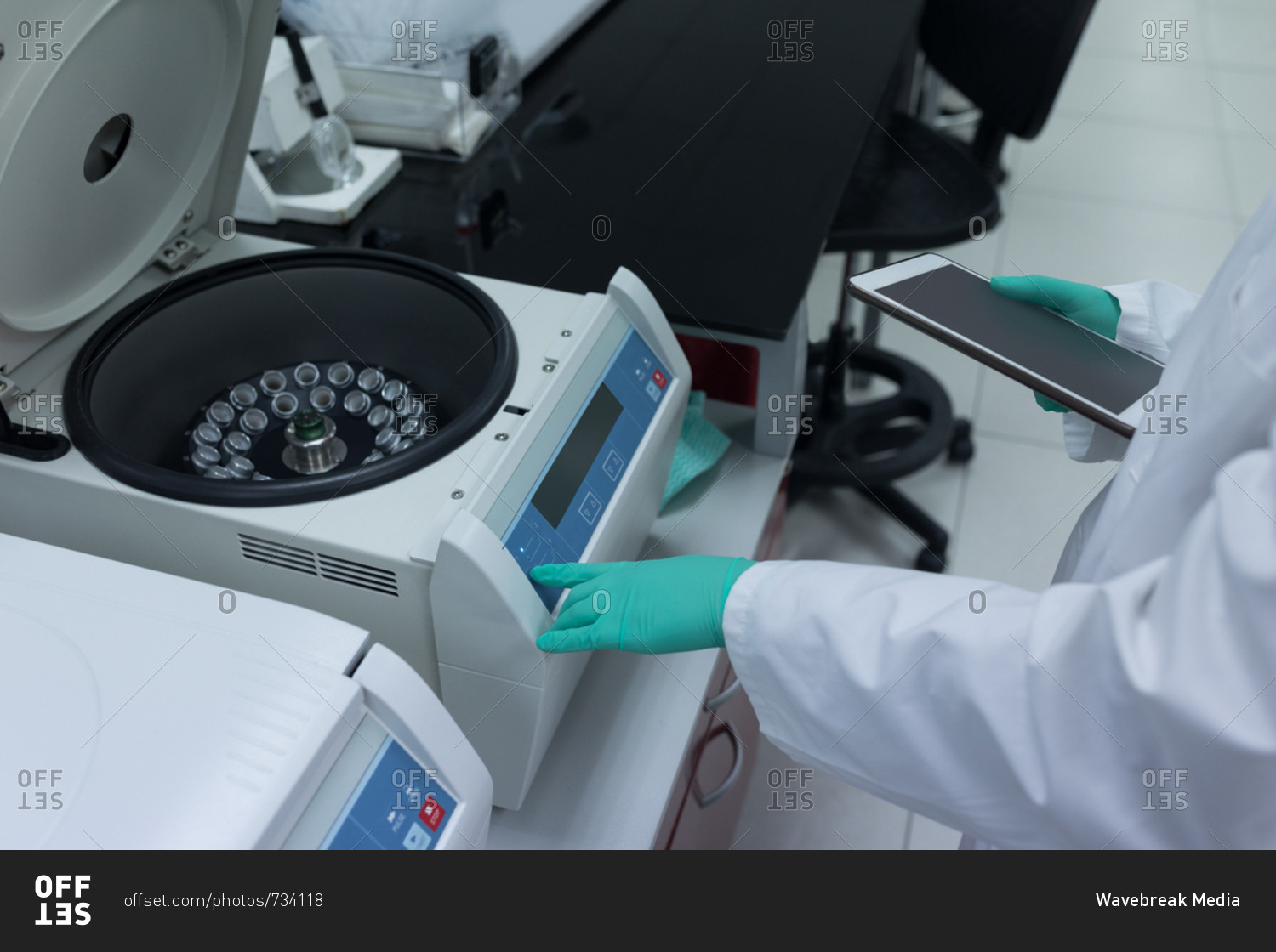 Laboratory technician using refrigerated centrifuge machine in blood