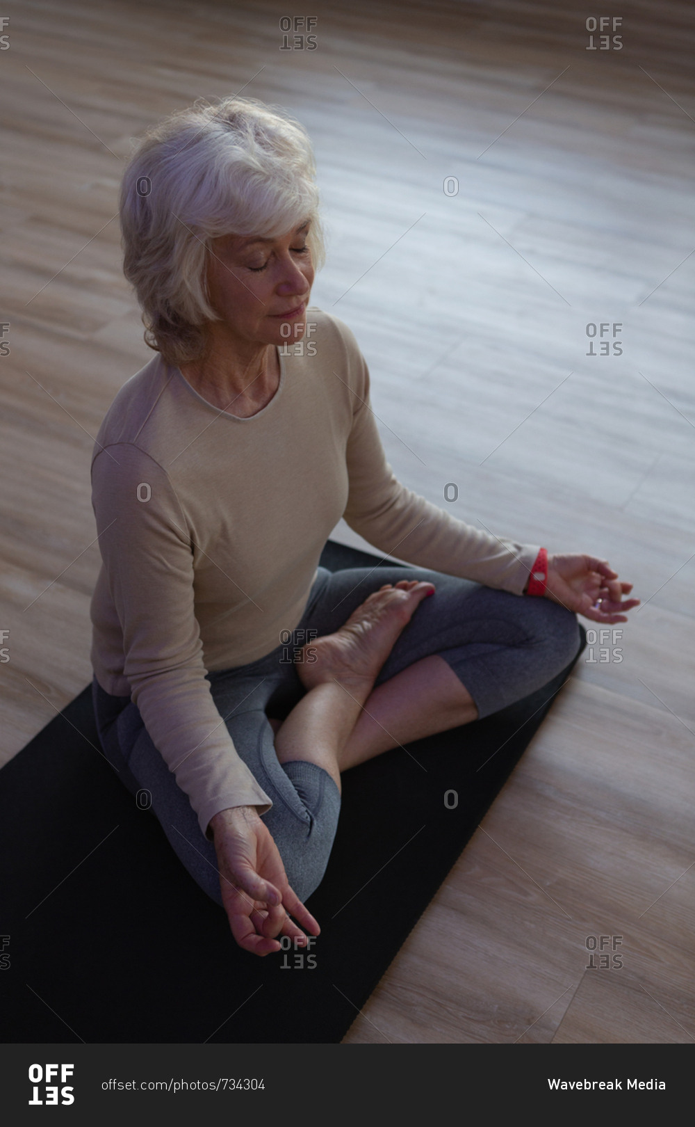 Senior woman performing yoga in yoga center