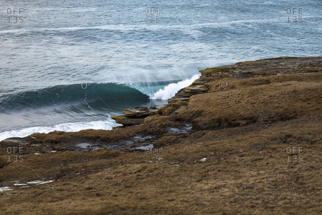 Rolling ocean waves breaking along rocky coastline