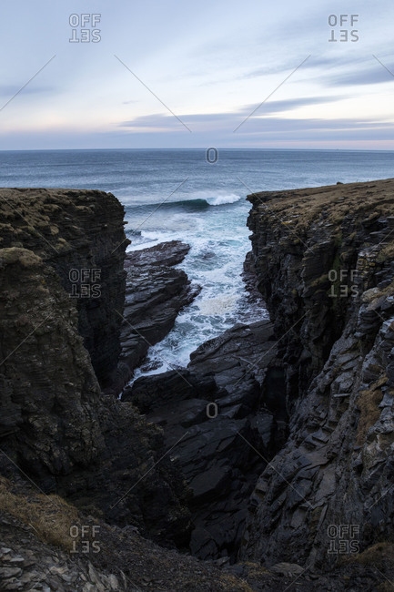 Waves breaking in narrow inlet on rocky coast
