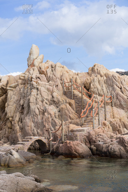 Tiny bridge and stairs leading up on a hill at the water.
