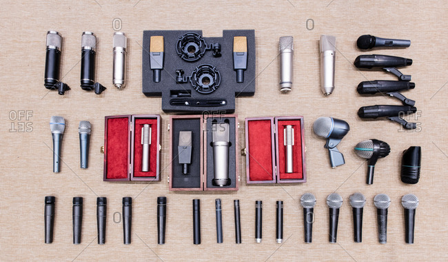 Arrangement of various modern microphones on beige texture background