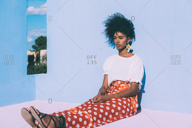 Black woman sitting in a colorful geometric building roof terrace