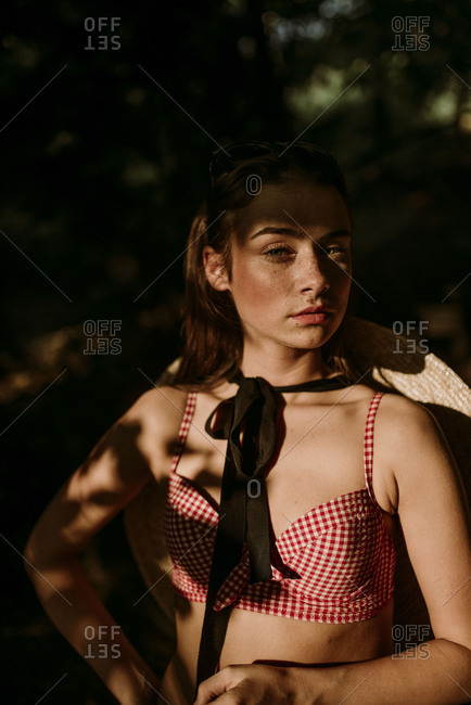 Woman with freckles standing in shadow
