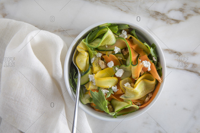 Fresh salad with raw zucchini served in a bowl