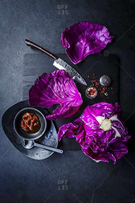 Raw red cabbage with chili flakes and salt on a wood board