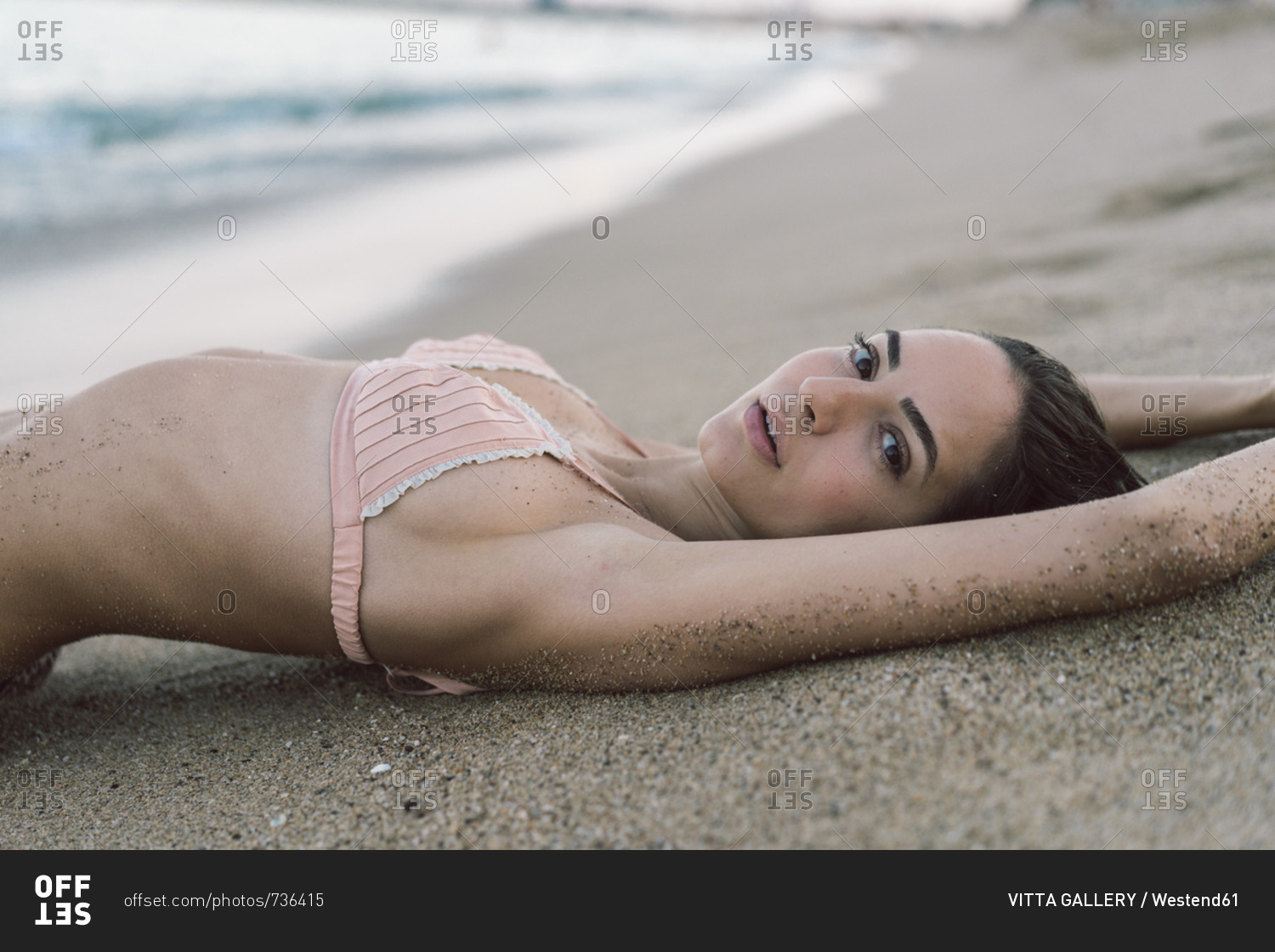 Beautiful woman lying on the beach stock photo - OFFSET