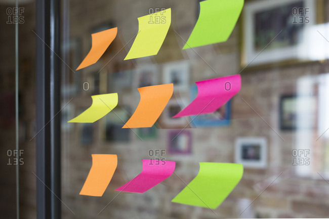 Adhesive notes on glass wall in office