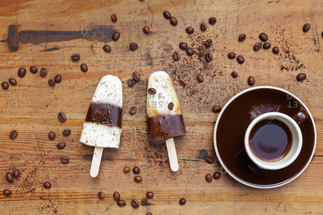 homemade Espresso Macchiato ice lollies with cup of Espresso and coffee beans on wooden background