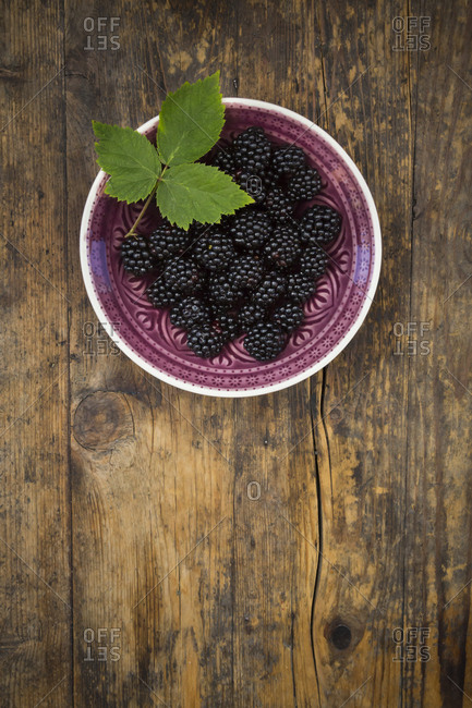 Bowl of organic blackberries on wood