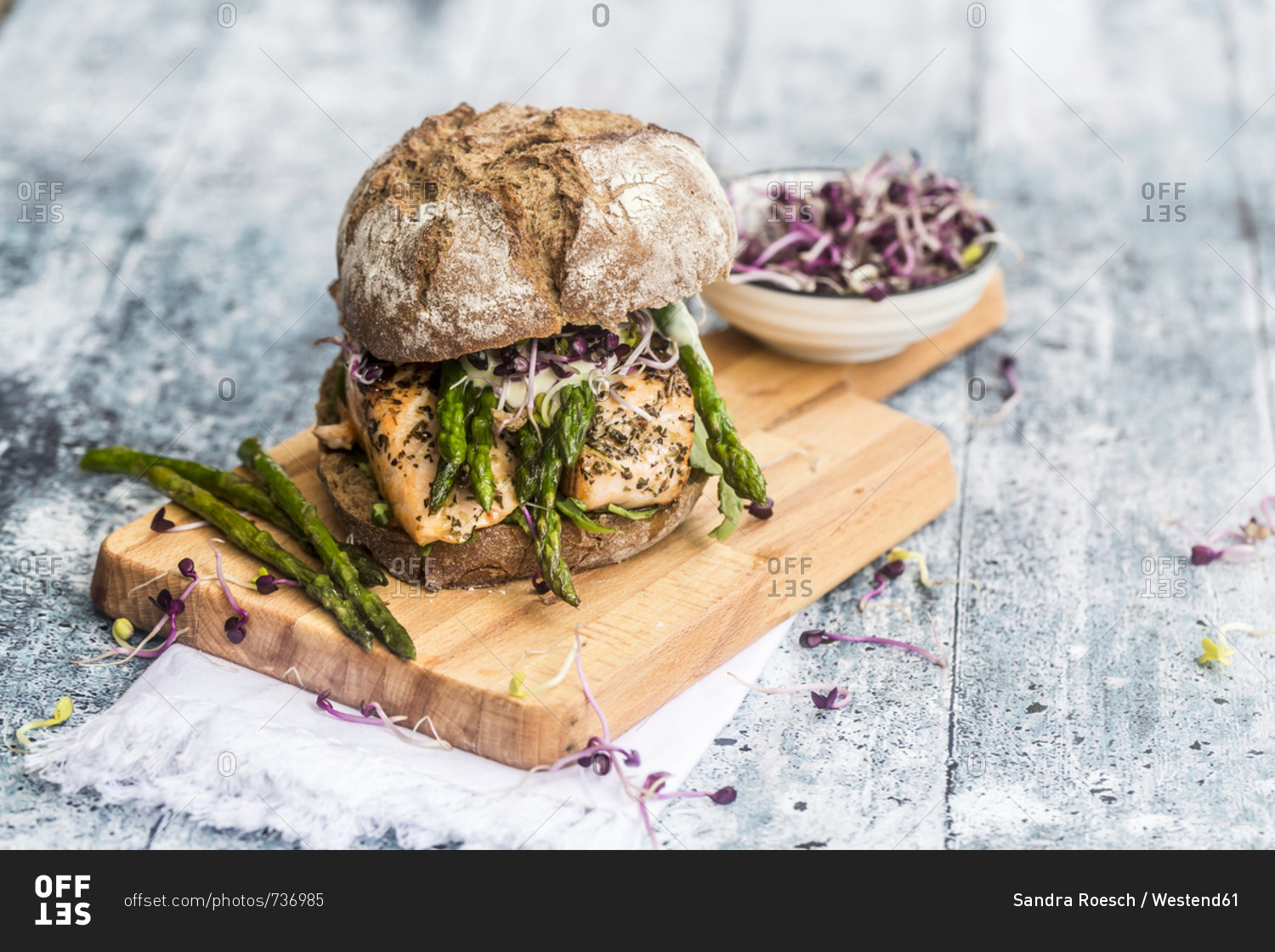 Salmon burger with green asparagus and red cress on chopping board
