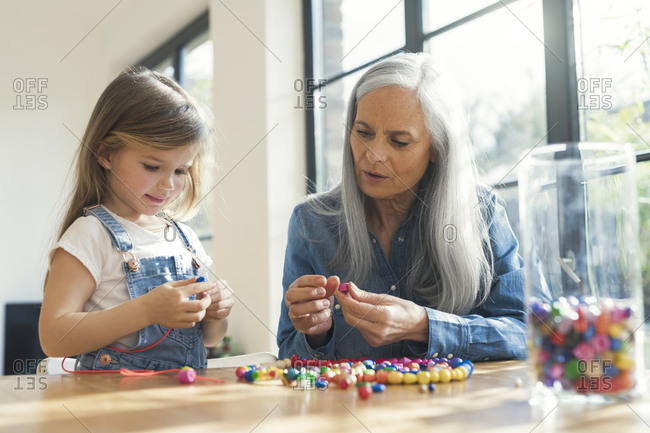 Grandmother and granddaughter threading beads