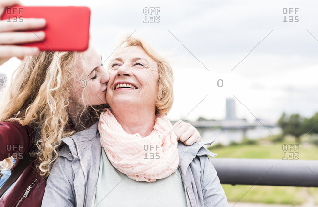 Grandmother and granddaughter taking selfie with smartphone