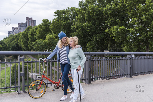 Grandmother and granddaughter strolling on a bridge