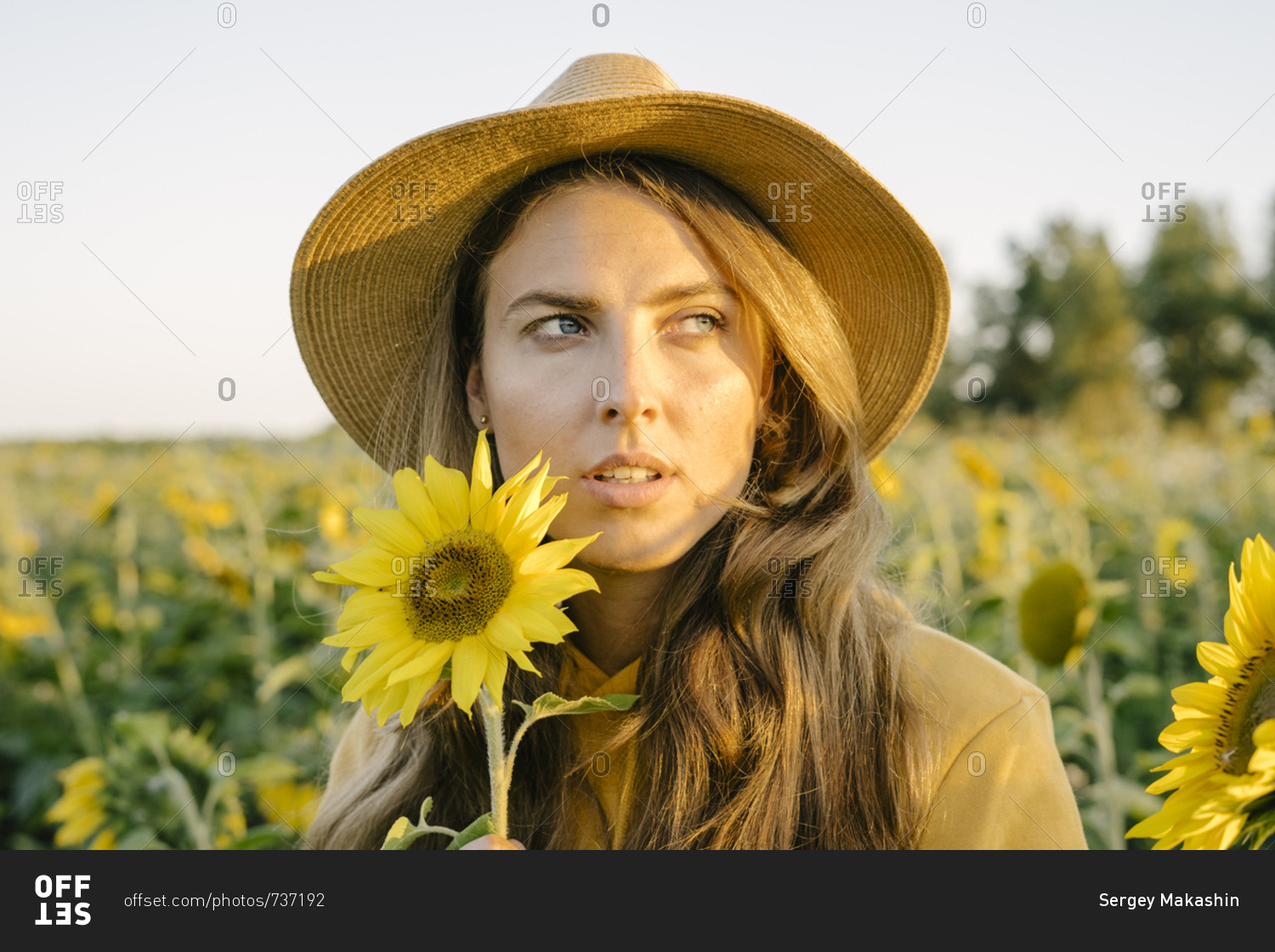 Portrait of a beautiful young woman holding a sunflower