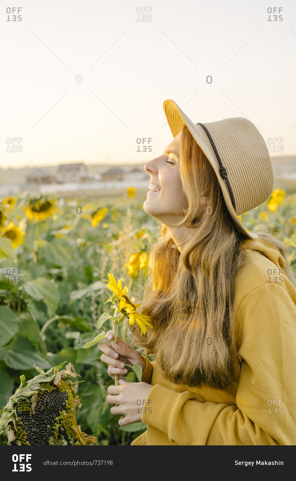 Portrait of a beautiful young woman holding a sunflower