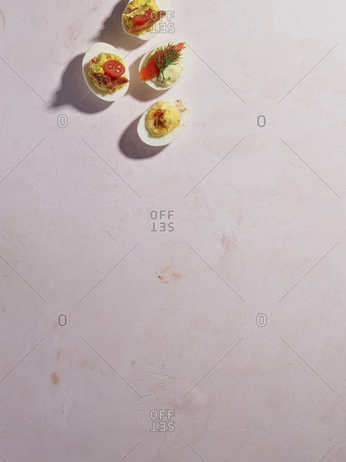 Four deviled eggs with a variety of toppings