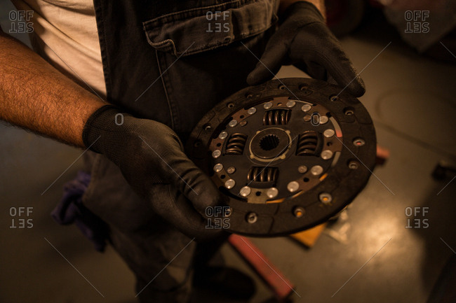 Mid section of male mechanic holding mac wheel