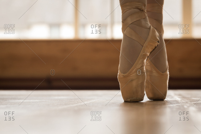 Low Section Of Ballerina Dancing On Wooden Floor In Dance