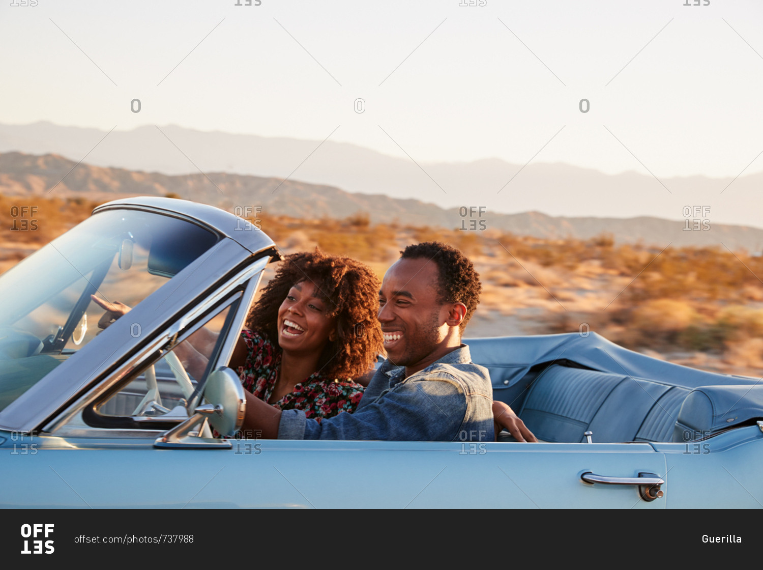 Young black couple driving on a desert highway, close up