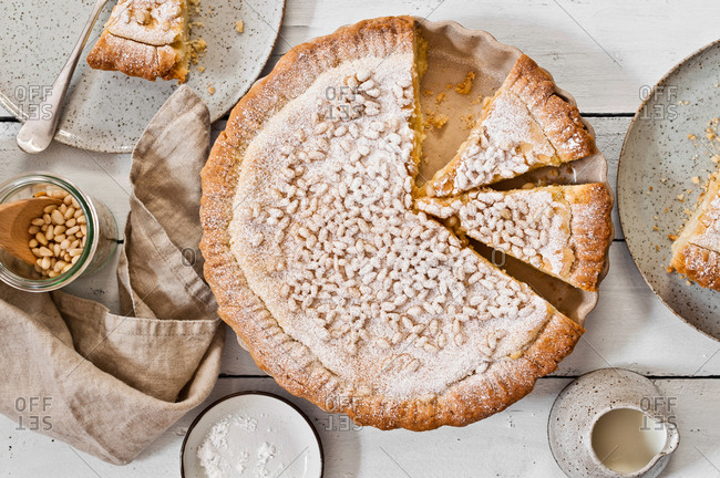 Overhead view of a custard pie topped with pine nuts