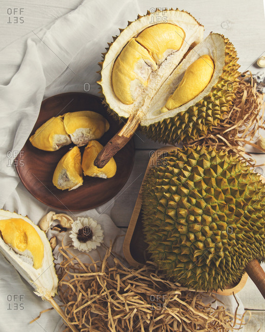 Whole and sliced durians with fruit served on plate
