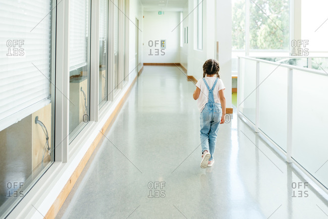 Little girl walking in hallway at school