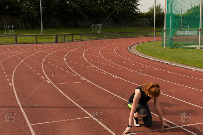 Female runner in a sprint on track stock photo - OFFSET