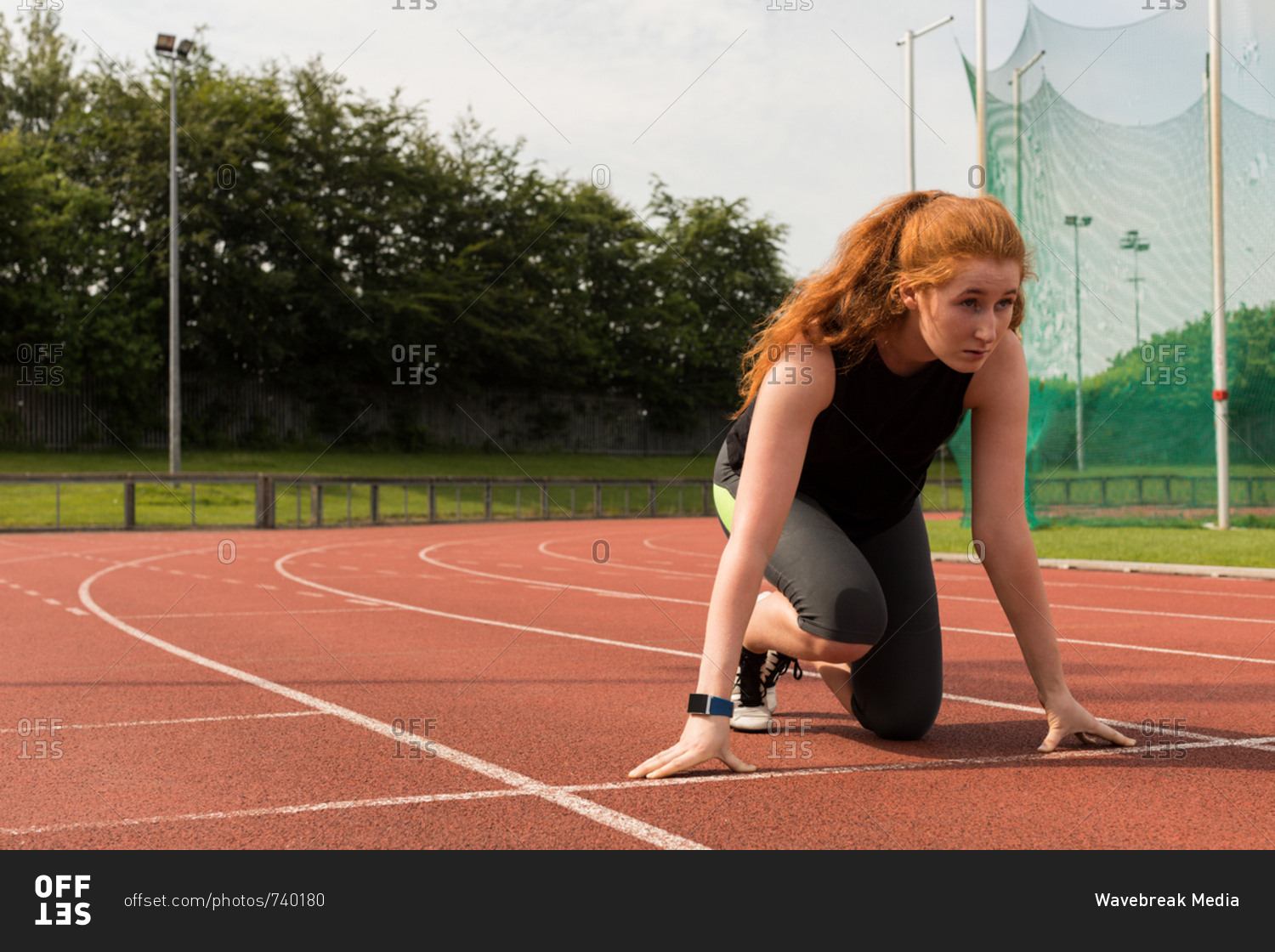 Female runner in a sprint on track stock photo - OFFSET