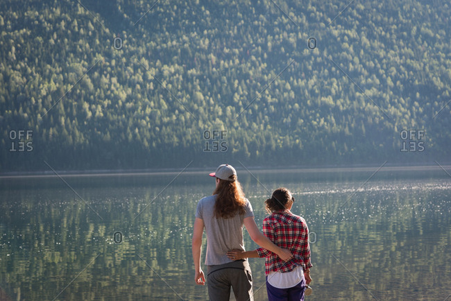 Rear view of couple standing near riverside