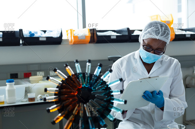 Female scientist writing on clipboard in laboratory