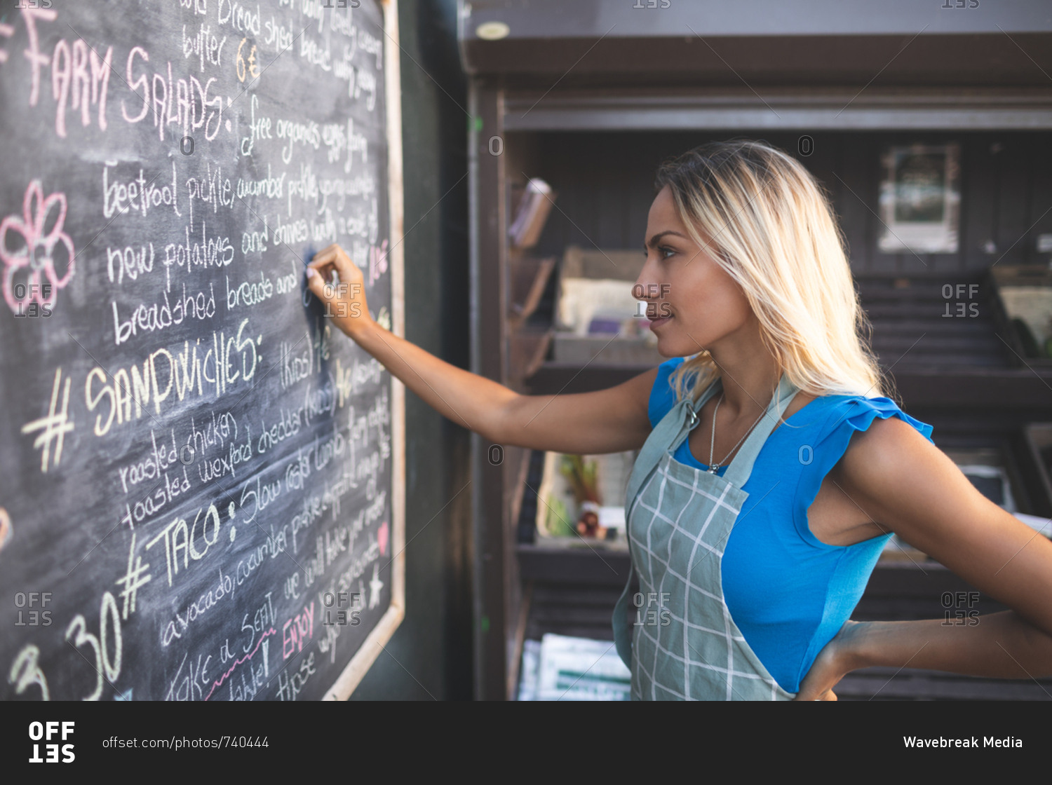 Female waitress writing order on menu board in food truck