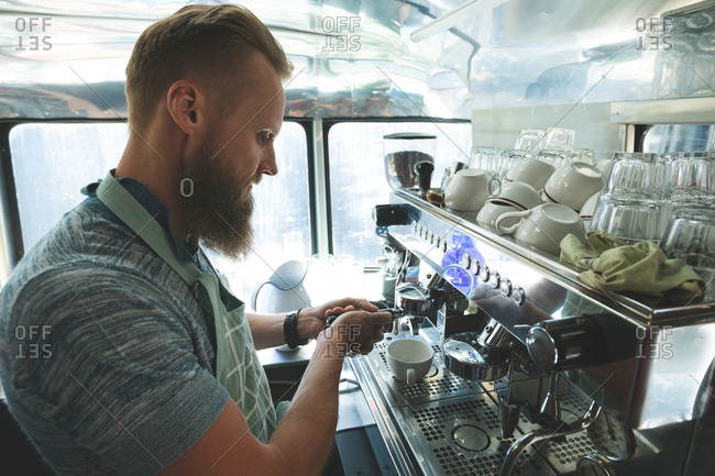 Side view of waiter preparing coffee in food truck
