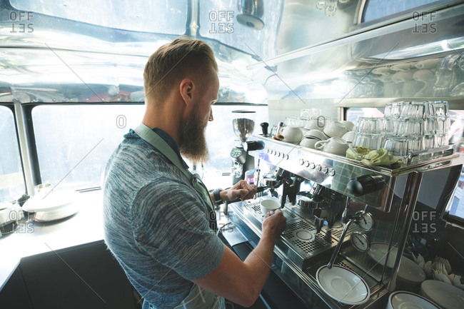 Side view of waiter preparing coffee in food truck
