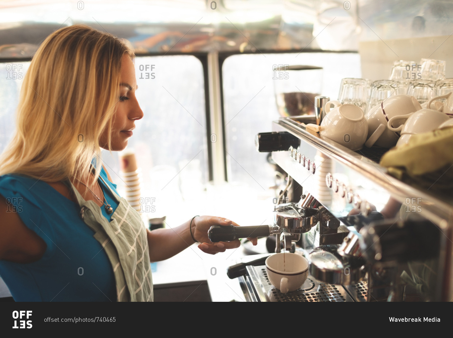 Side view of female waiter preparing coffee in food truck