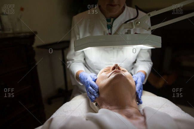 Cosmetologist giving woman a face massage