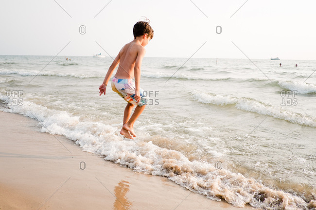 Boy jumping in the waves on the beach