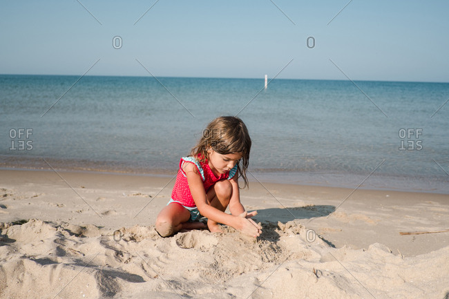 Girl playing in the sand on the beach