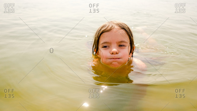 Portrait of a girl holding her breath while swimming with her head above water