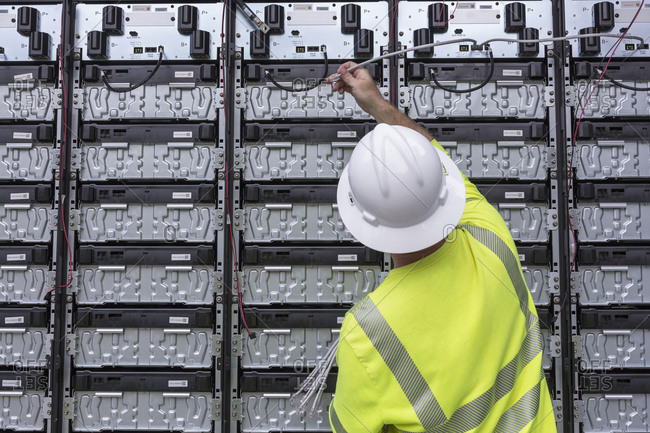 Engineer connecting energy storage batteries for backup power to an electric power plant.