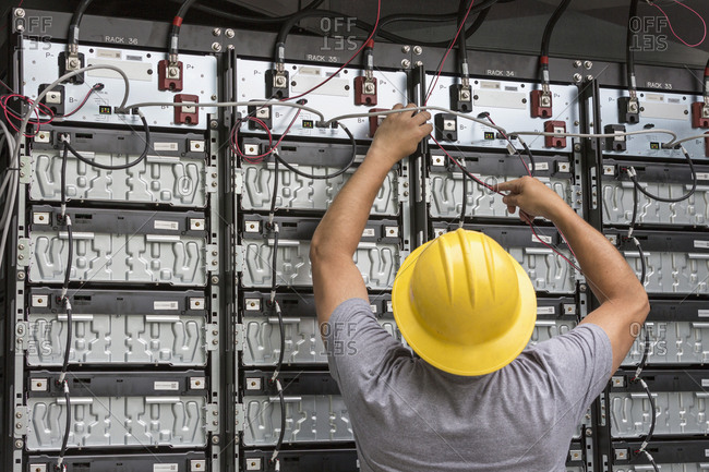 Engineer connecting energy storage batteries for backup power to an electric power plant.