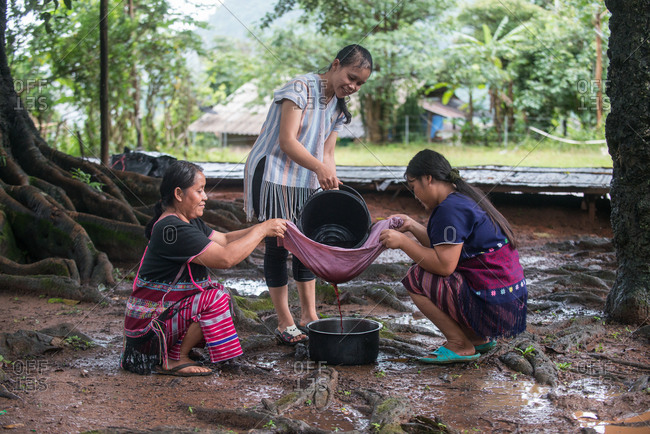 August 18, 2018: Asian Karen Hilltribe Women Filtering the Color to Dye Fabric. Chiang Mai,  Thailand.