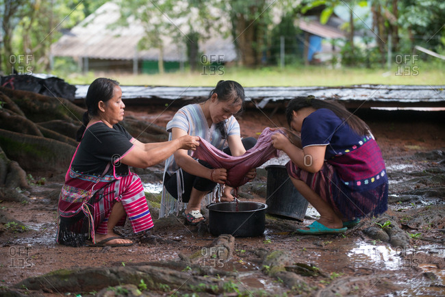August 18, 2018: Asian Karen Hilltribe Women Filtering the Color to Dye Fabric. Chiang Mai,  Thailand.