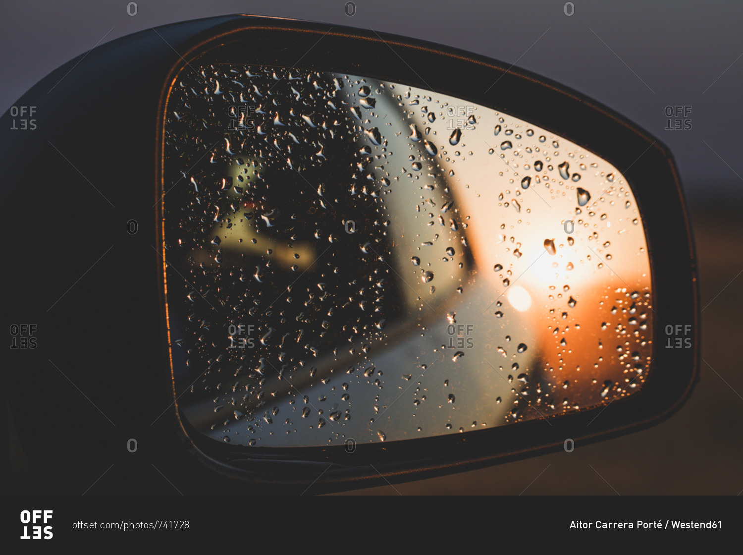 Raindrops Reflecting On Rear View Mirror Of Car During Sunset