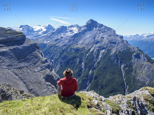 Italy- Lombardy- Sondrio- hiker resting with view to Stelvio Pass and Ortler