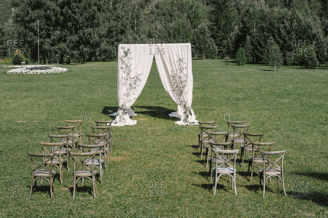 Wedding ceremony with a square arch and wooden chairs. rustic wedding in nature. mountain and forest view
