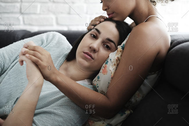 Portrait of woman relaxing on girlfriend's chest at home